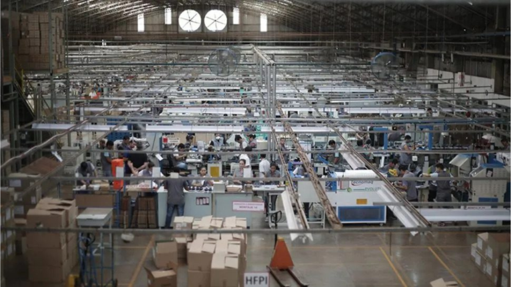 Operarios en una fábrica textil y de calzado en Argentina enfrentando la ociosidad productiva por la recesión.