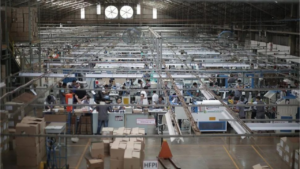 Operarios en una fábrica textil y de calzado en Argentina enfrentando la ociosidad productiva por la recesión.